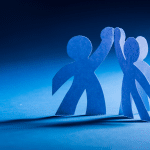 Graphic depicting paper cutouts of people giving a high five to illustrate employee engagement